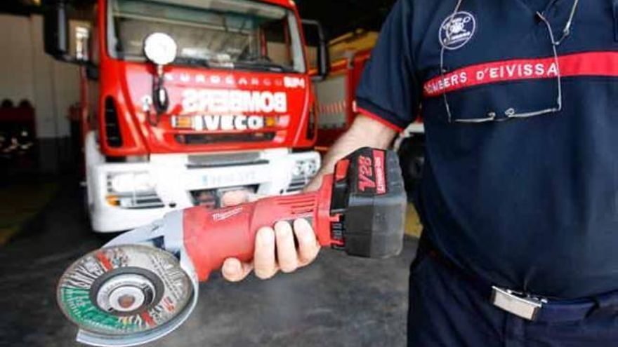 Un bombero muestra la radial que utilizaron para cortar el aro de acero.