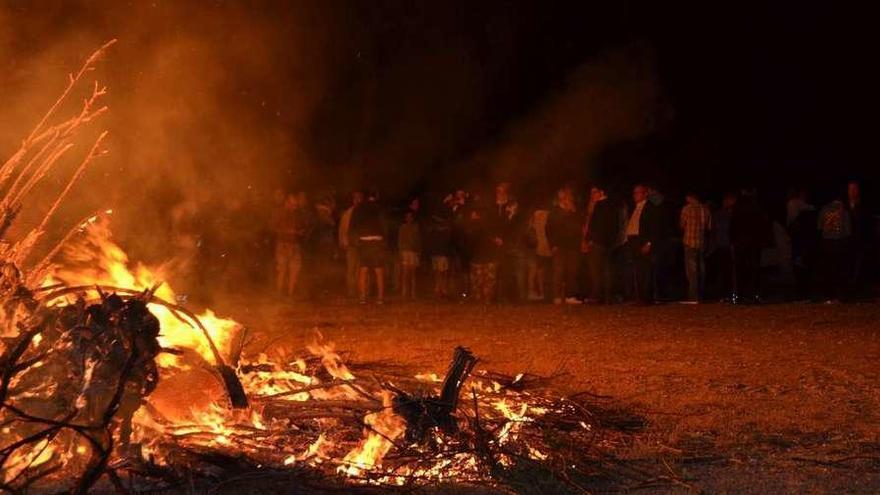 Vecinos de Ribadelago esperan a la consumición del fuego.