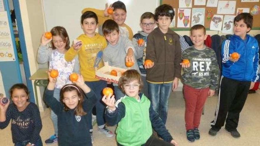 Algunos de los escolares muestran piezas de fruta. // FdV