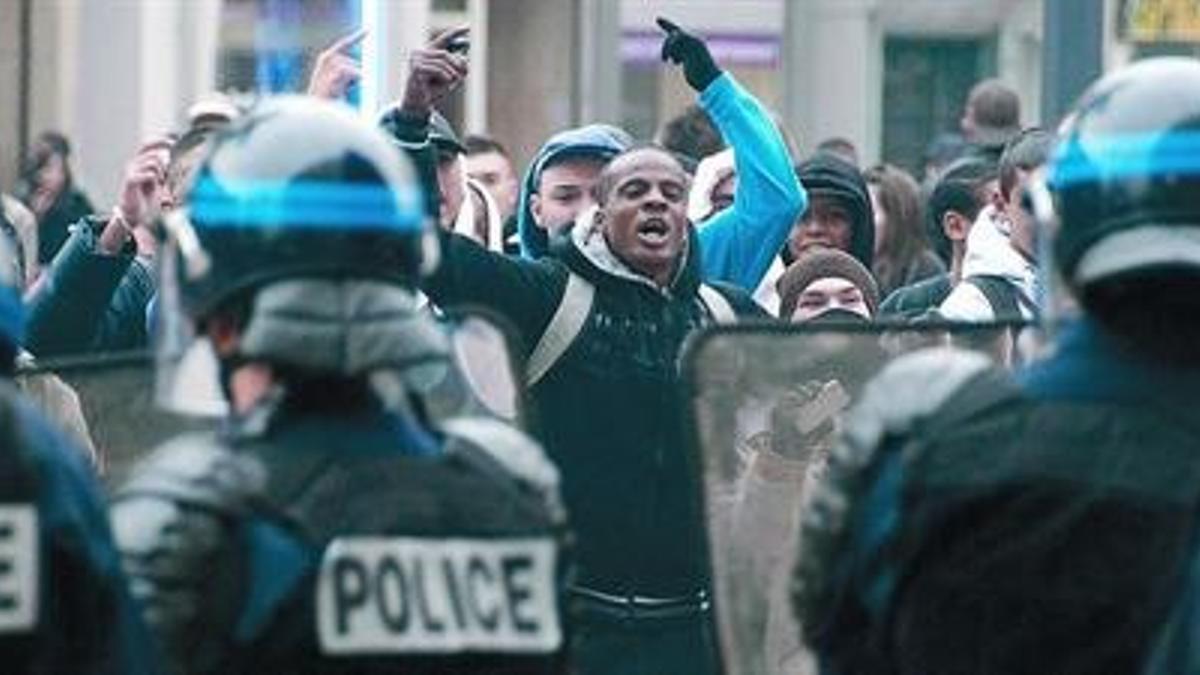 Agentes policiales se plantan ante un frente de jóvenes vociferantes en Mulhouse, ayer, en el este de Francia.