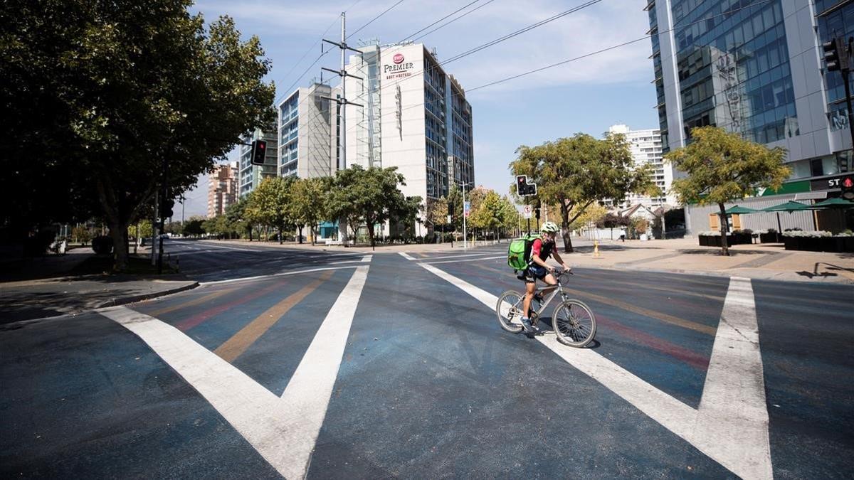 Un repartidor en bicicleta en una calle desierta