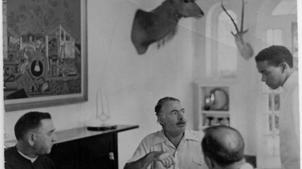 Ernest Hemingway con unos amigos en el comerdor de Finca Vigía presidido por 'La masía'.