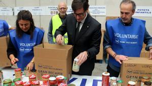 El president de la Generalitat, Salvador Illa, ajuda a omplir una capsa amb menjar del Banc dAliments