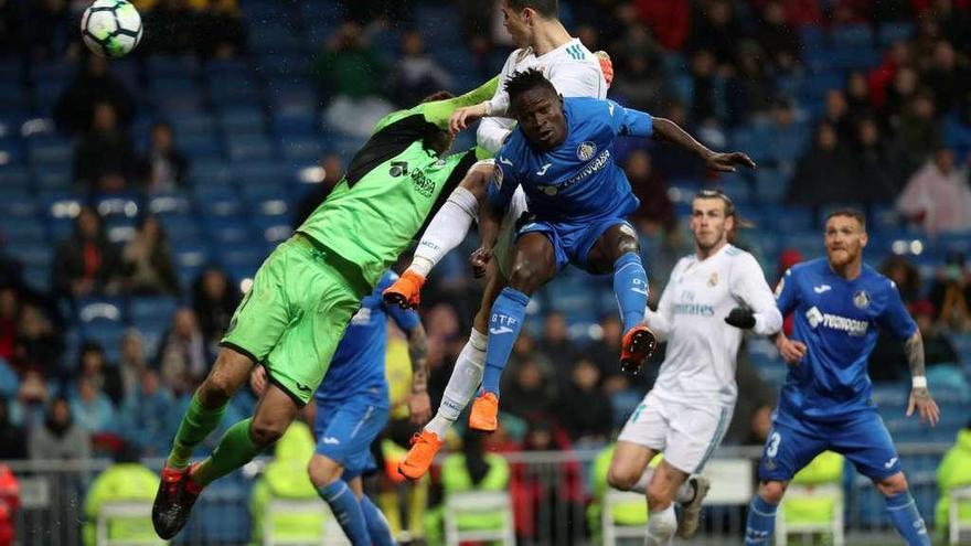 Cristiano Ronaldo supera en el salto al portero y a un defensor del Getafe.