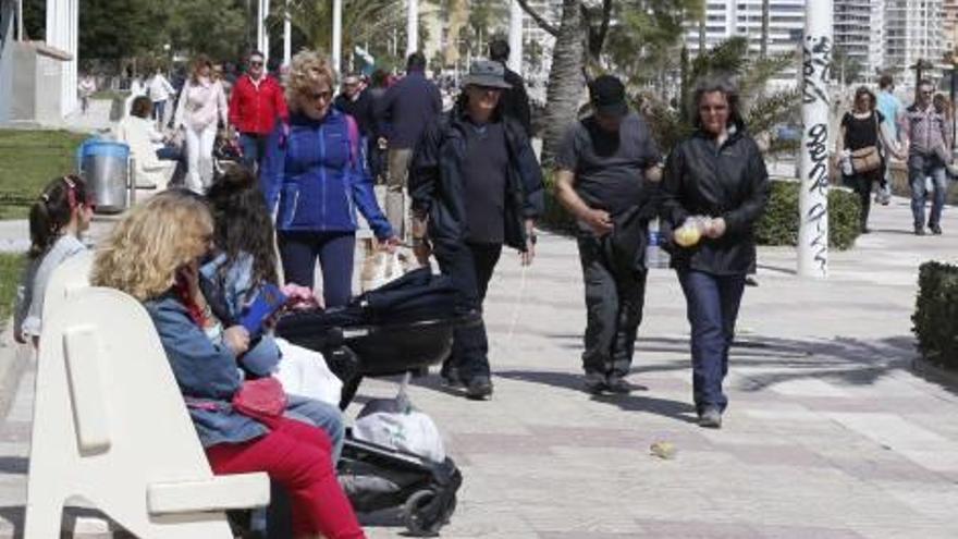 Un grupo de personas pasea por el paseo marítimo de Cullera.