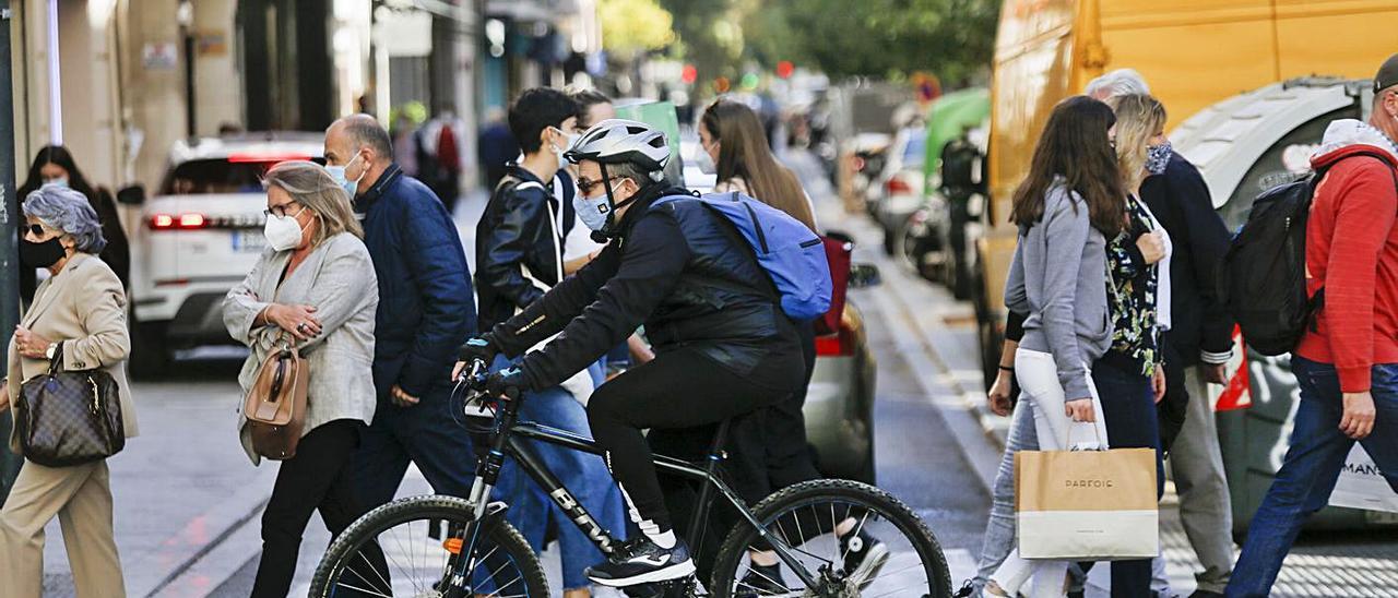 Una de las vías comerciales de València con gente con bolsas de la compra, ayer.  | EDUARDO RIPOLL