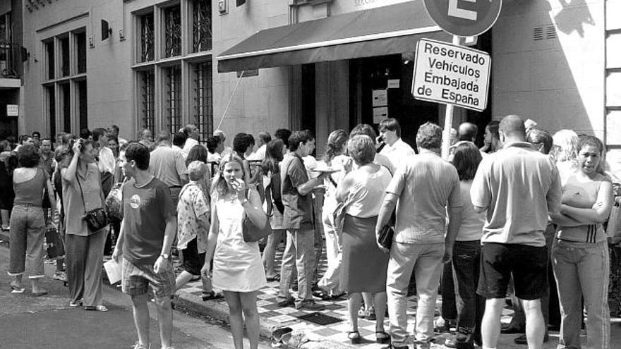 Decenas de personas aguardan a que la embajada española en Buenos Aires abra sus dependencias.