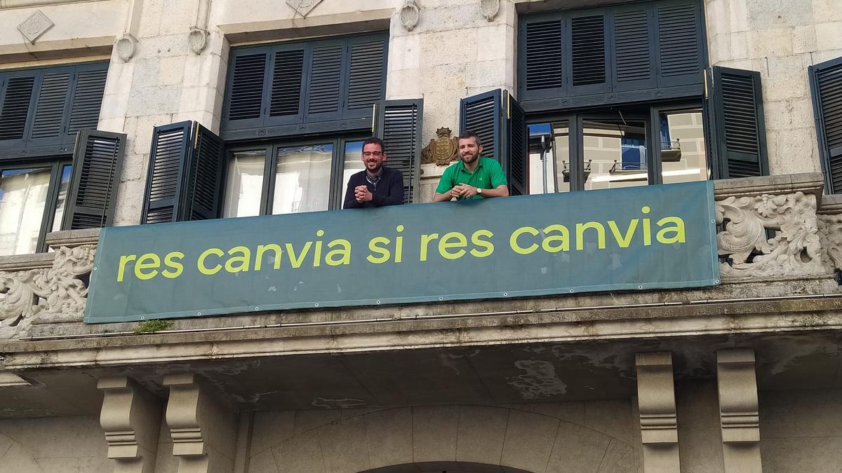 L'alcalde Lluc Salellas, i el regidor d'Acció Climàtica Sergi Cot, al balcó de l'Ajuntament amb el lema de la marca.