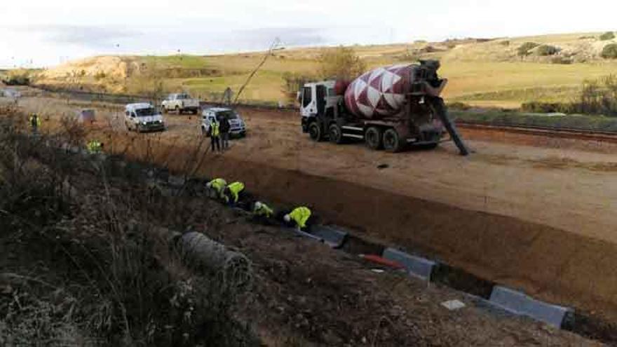 Operarios trabajando en una tubería de desagüe de la plataforma del AVE.