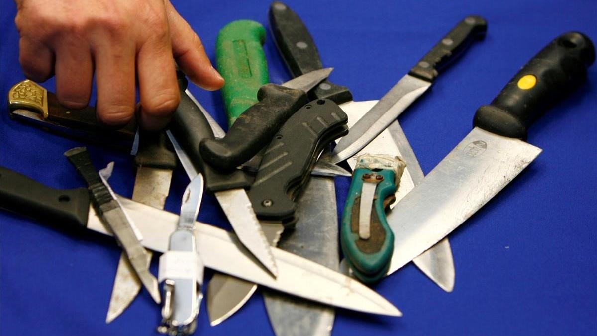 Un representante de la Policía Metropolitana organiza cuchillos incautados en operaciones en Londres