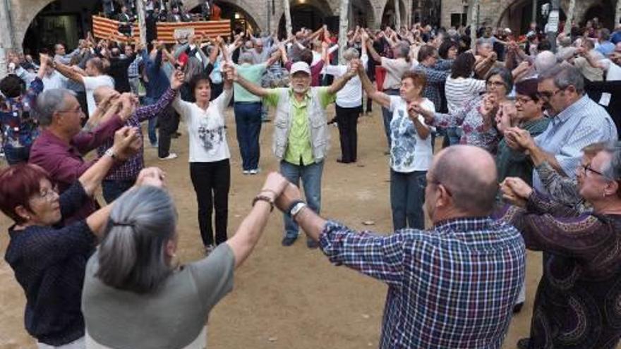Un grup de gent, ballant sardanes a la plaça Major.