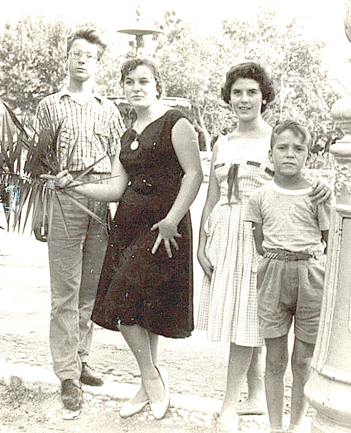 Manolo Reina en su adolescencia, con sus hermanosy Mari Pili Doñate, en la fuente del Parque.