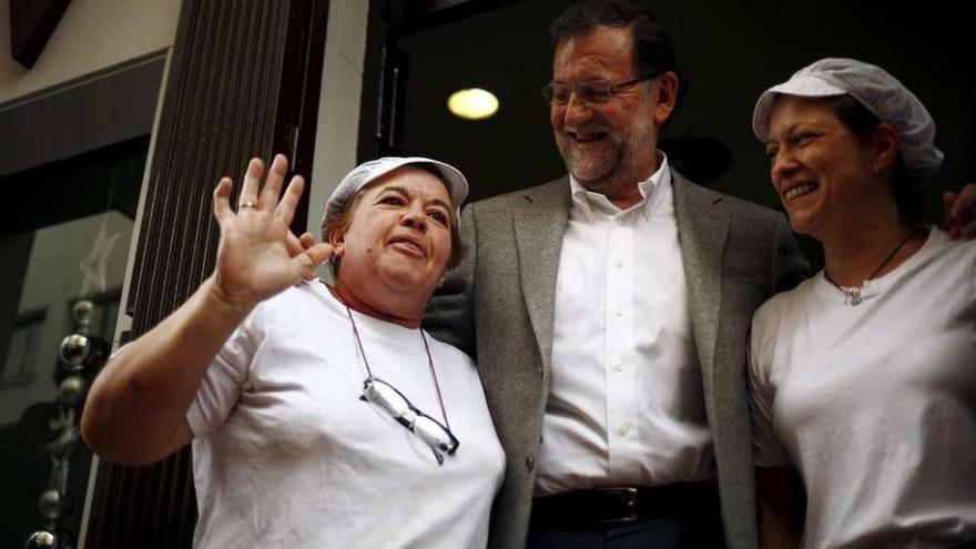 Rajoy se fotografía sonriente con las empleadas de un local de hostelería en Estepona (Málaga). // Reuters