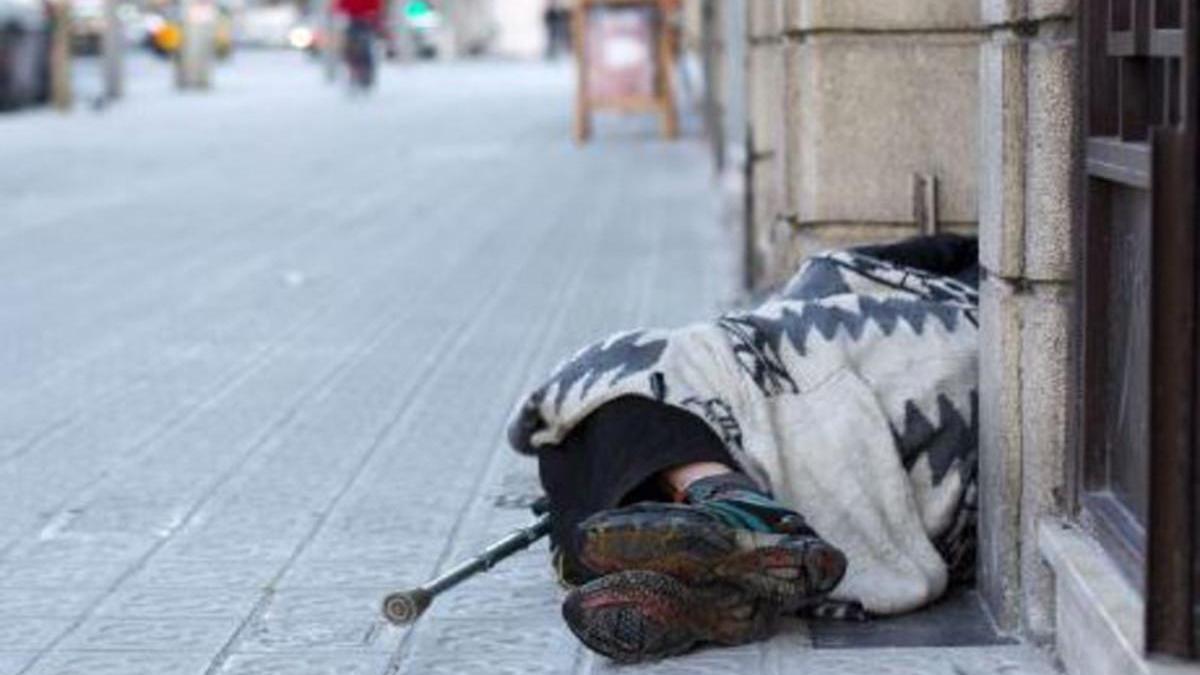 Una persona sin hogar duerme en una calle de la capital catalana