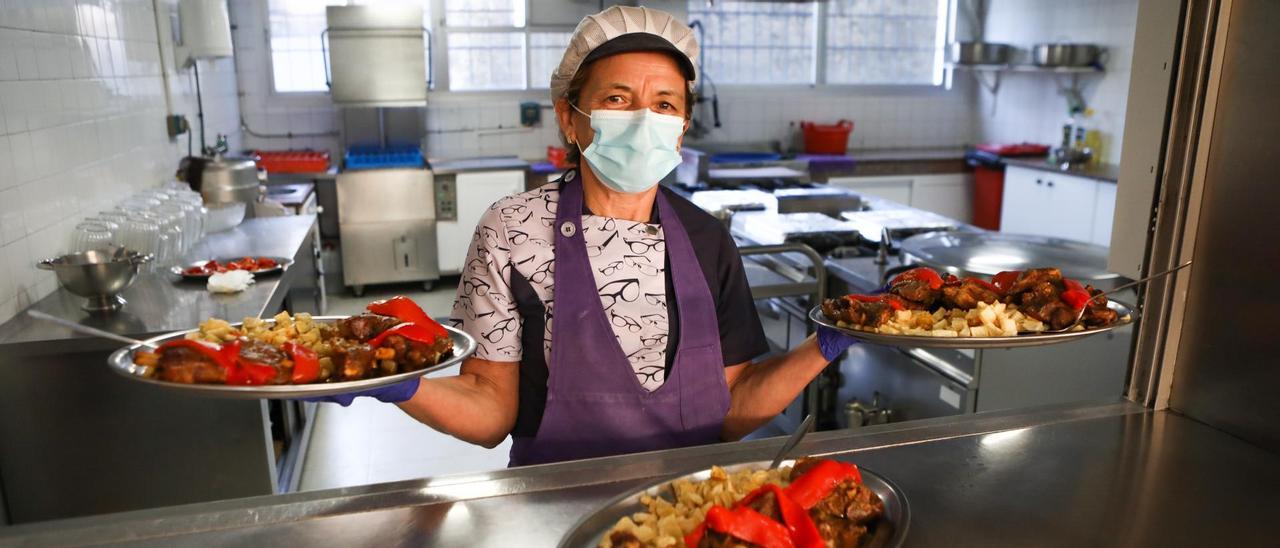 Tina Carballo, cocinera del colegio de Covelo, muestra las fuentes de cordero.// Anxo Gutiérrez