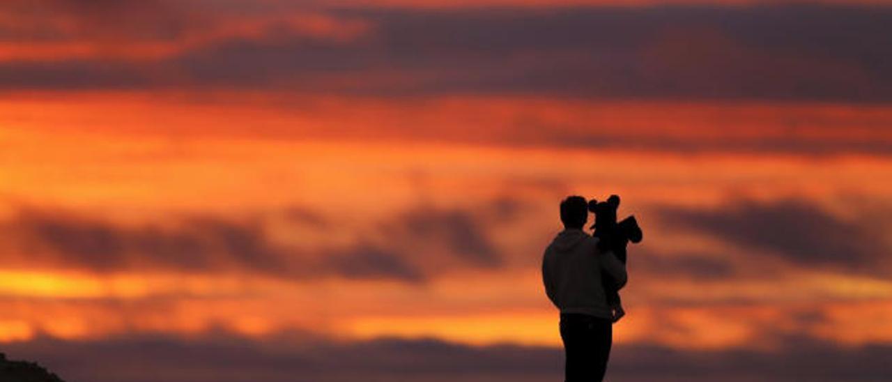 Un padre con su hija contempla la puesta de sol, en una fiesta que se celebra el 19 de marzo en países como Portugal, Italia o Macao.