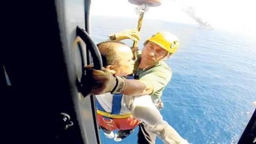 Ein Hubschrauber der Guardia Civil rettet ein Besatzungsmitglied der in Brand geratenen Fähre.