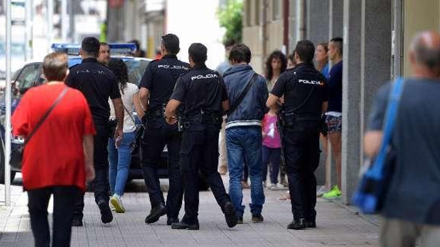 Los agentes llevan al varón al coche policial. // G. Santos