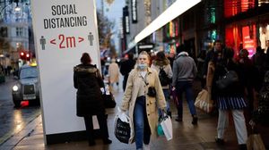 Shoppers and pedestrians walk past a sign advising social distancing in Oxford Street in central London on December 14  2020  as it is announced that Greater London will be moved into Tier 3 from Tier 2 from Wednesday December 16  - London is to move into the highest level of anti-virus restrictions  the health minister announced Monday  The British capital from Wednesday will go into  tier three  restrictions  which force the closure of theatres and ban people from eating out at restaurants or drinking in pubs  the Health Secretary Matt Hancock told parliament  (Photo by Tolga Akmen   AFP)