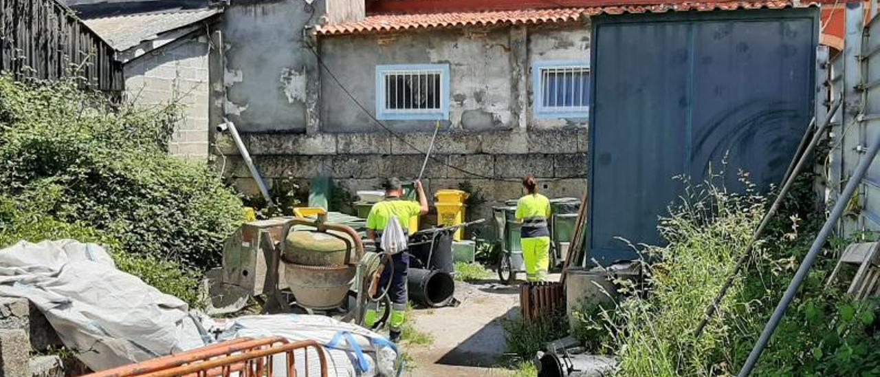 Personal del servicio de limpieza viaria municipal en el solar situado al lado del Concello de Bueu. |   // FDV