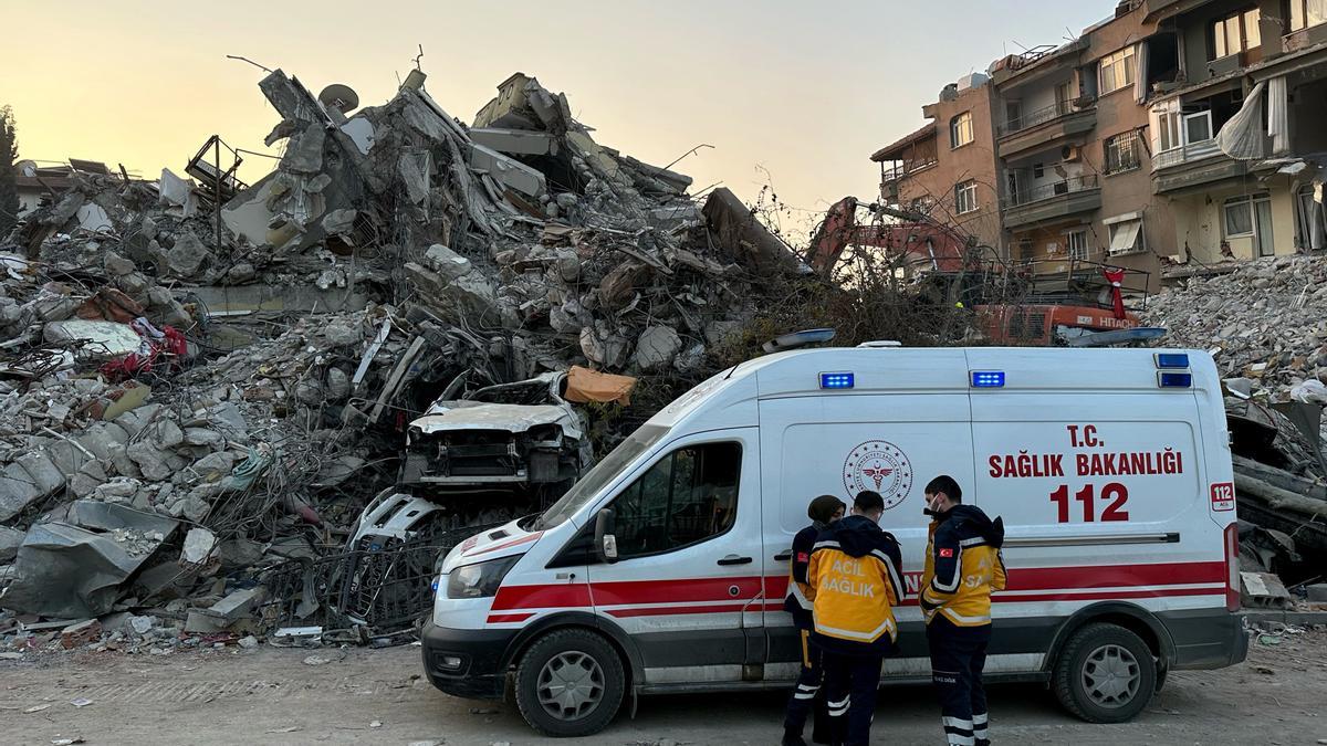 Los equipos sanitarios turcos al lado de un edificio en ruinas por el terremoto.