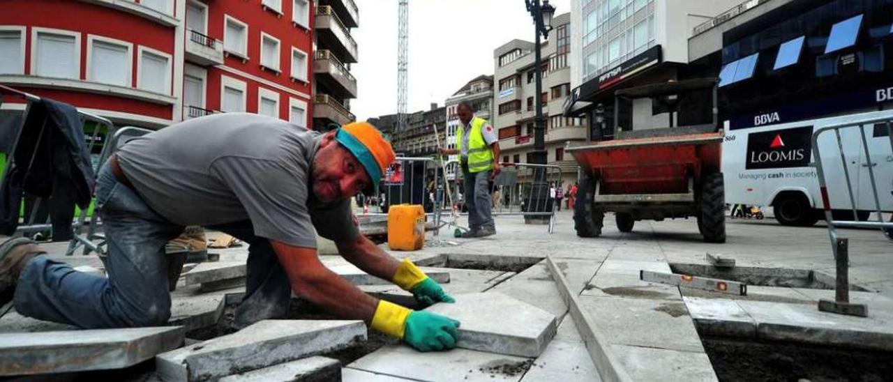 Los operarios municipales colocan las losetas de piedra en la Plaza de Galicia. // Iñaki Abella