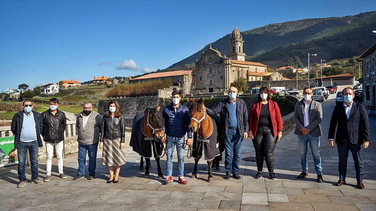 Representantes de las entidades participantes en el proyecto, los caballos y su criador, Adrián Martins, ayer en la presentación del proyecto &quot;Do Mosteiro a Santiago&quot; en Oia.