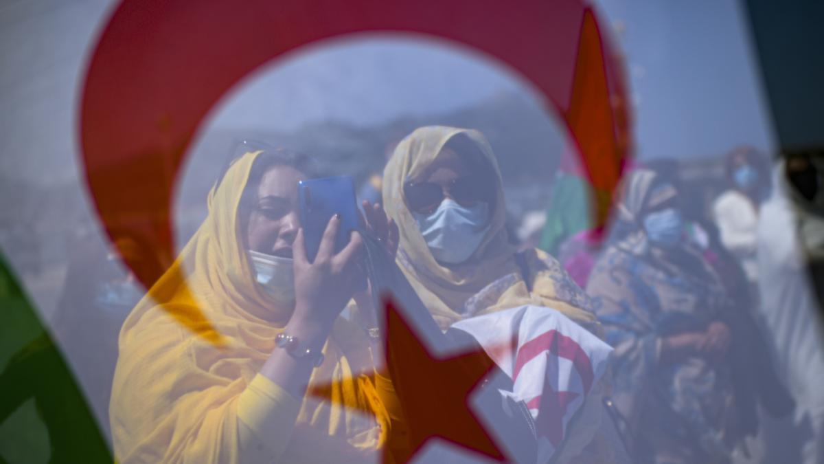 Saharische Demonstrantinnen stehen hinter einer Fahne des Westsaharas bei einem Protest zur Unterstützung des Chefs der Unabhängigkeitsbewegung Polisario in Westsahara am Strand von La Concha. Im Streit um die von Marokko seit knapp 50 Jahren beanspruchte Westsahara hat Spanien 2022 den Weg zur Lösung des Konflikts geebnet.