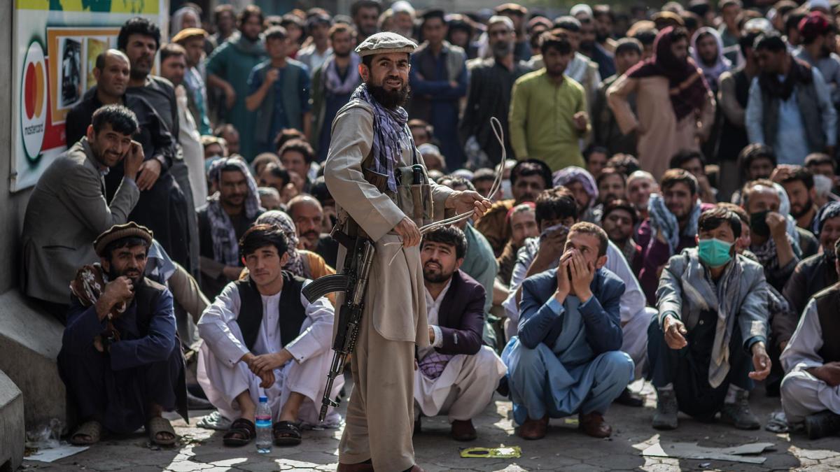 Un miliciano talibán guarda la cola para retirar dinero en Kabul.
