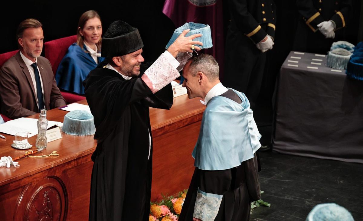 Un instante del acto celebrado en el Paraninfo de La Laguna cuando el rector coloca el birrete a uno de los doctores.
