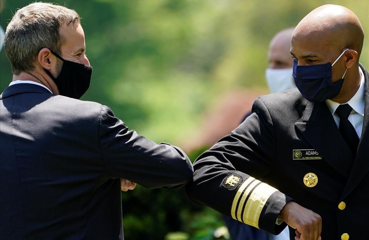 El cirujano general de los EEUU, Jerome Adams, golpea el codo con el CEO de la Corporación Financiera de Desarrollo Internacional, Adam Boehler, durante un evento de respuesta a la pandemia.