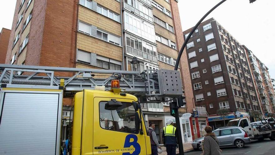 El camión de los bomberos, ayer por la mañana, en la calle de Ramón y Cajal, donde se produjo el desprendimiento de cascotes desde una novena planta de un edificio.