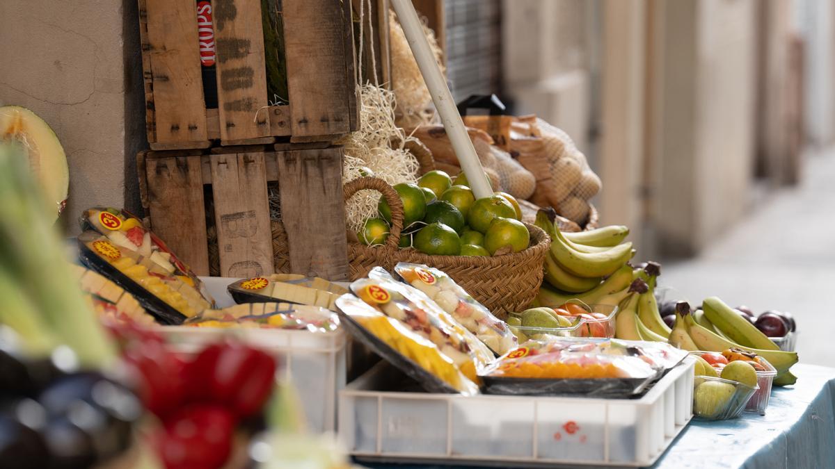 Varias frutas expuestas en el exterior de un comercio.