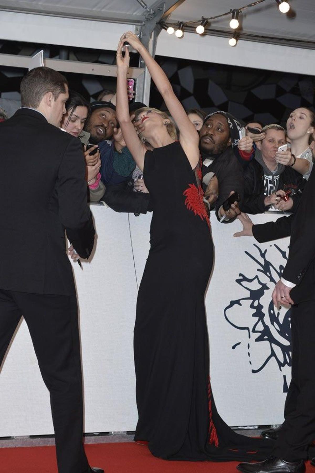 Taylor Swift se hace selfies con los fans en la alfombra roja de los BRIT Awards 2015.