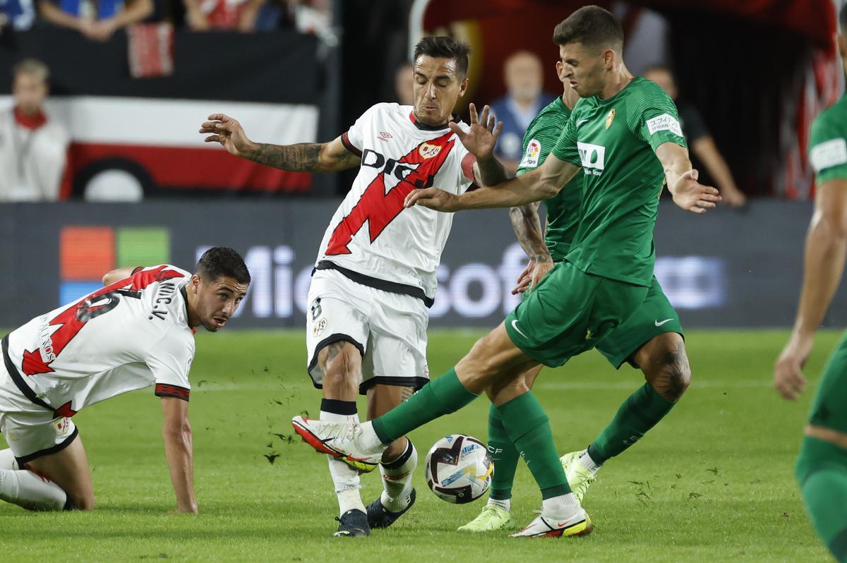 MADRID, 03/10/2022.- El delantero argentino del Rayo Vallecano, Óscar Trejo (i), disputa el balón ante el centrocampista del Elche, Gerard Gumbau, durante el encuentro correspondiente a la séptima jornada de primera división que disputan hoy lunes en el estadio de Vallecas, en Madrid. EFE / Juanjo Martín.