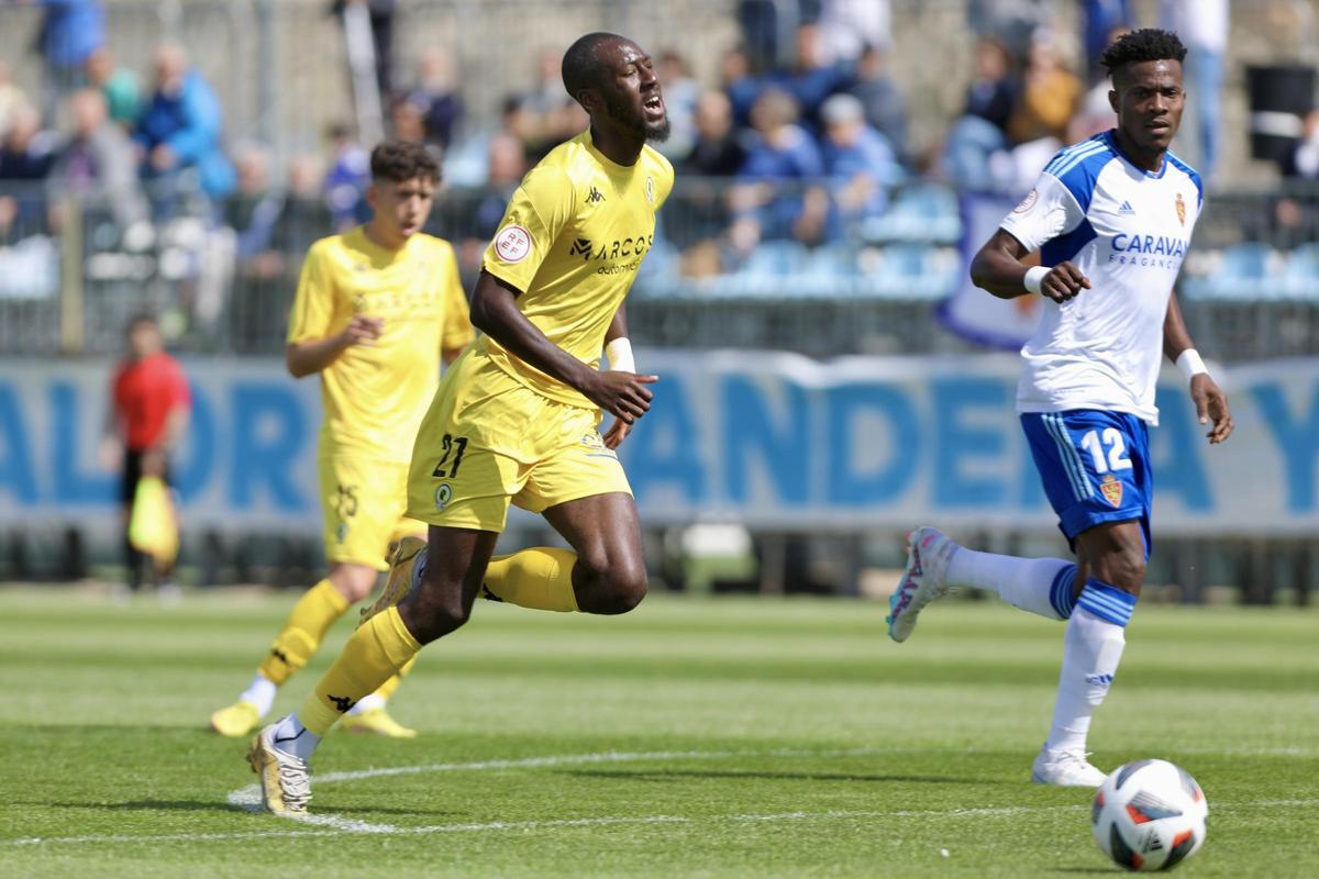 Jean Paul N’Djolí corre hacia un balón en ataque con evidentes síntomas de agotamiento en el rostro durante el partido en la ciudad deportiva del Real Zaragoza.