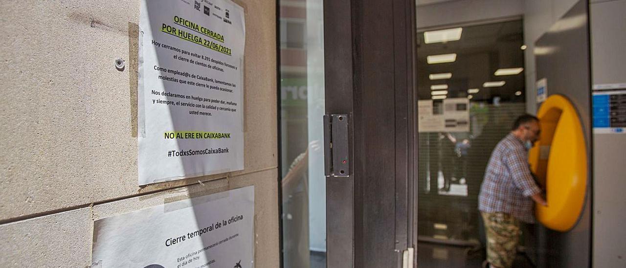 Una de las oficinas de CaixaBank del centro de Alicante, cerrada por la huelga.  | JOSE NAVARRO