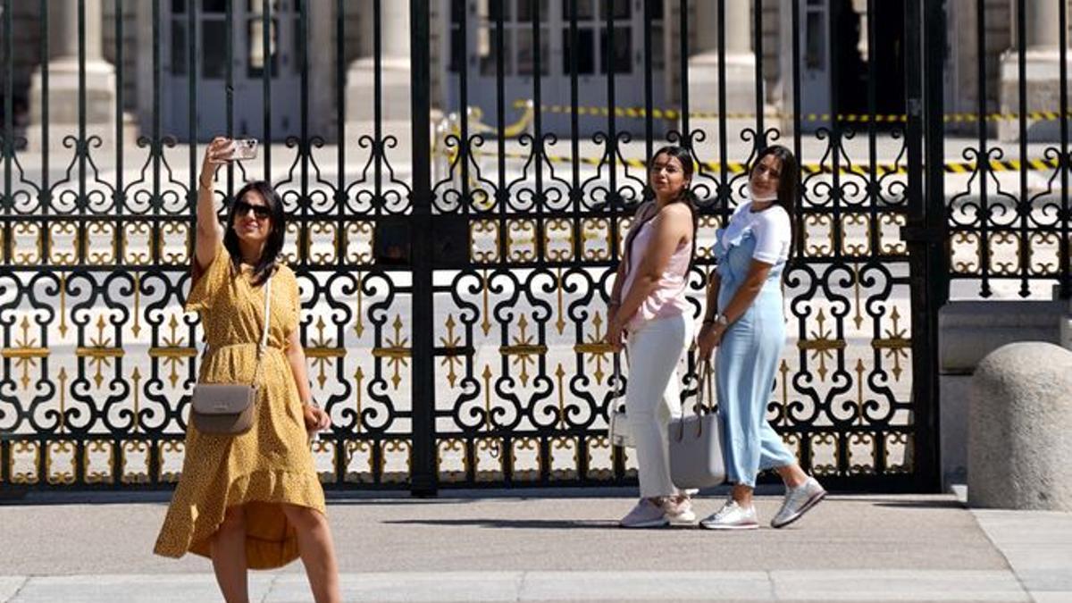 Turistas se hacen un selfie a las afueras del Palacio Real.