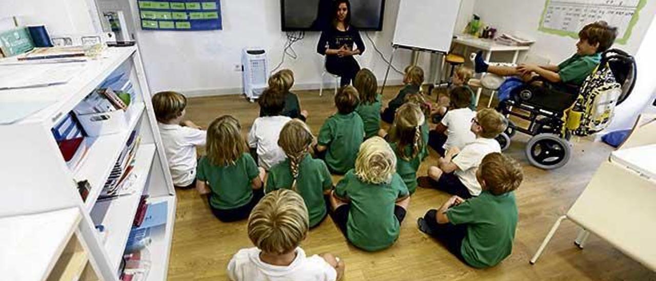 Un grupo de alumnos atiende a la maestra en una clase de Educación Primaria del sistema británico.
