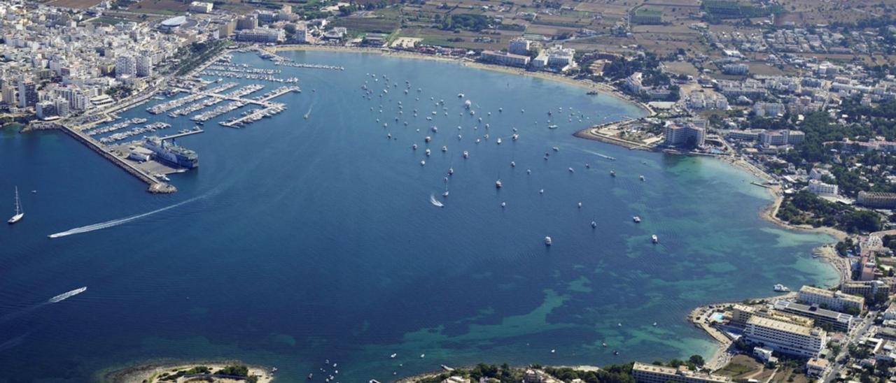 Vista aérea del puerto, la playa de s’Arenal y parte de la bahía de Sant Antoni. | CNSA