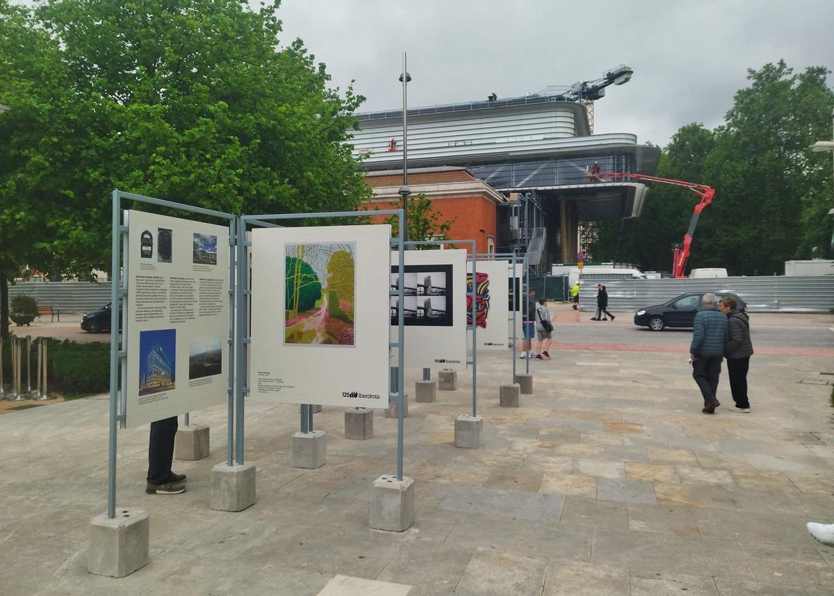 Paneles expositores sobre la muestra en el itinerario entre la Torre Iberdrola y el museo, con las obras de ampliación visibles al fondo.