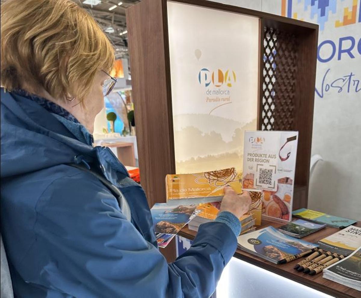 Una visitante recoge varios folletos promocionales del Pla.