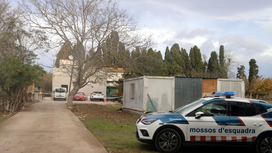 La casa custodiada amb un vehicle policial.