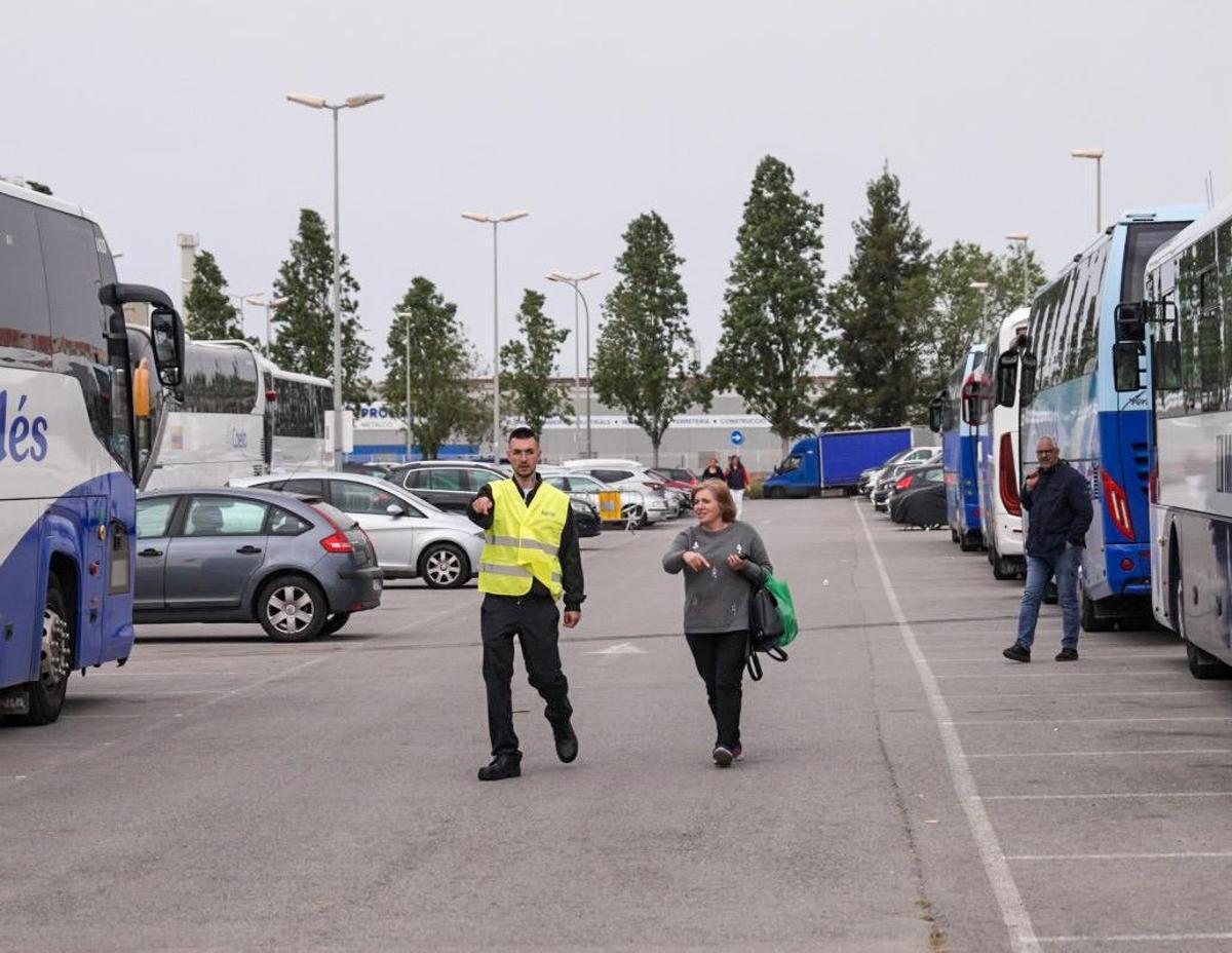 Una mujer cambiando de bus lanzadera en la estación del Prat