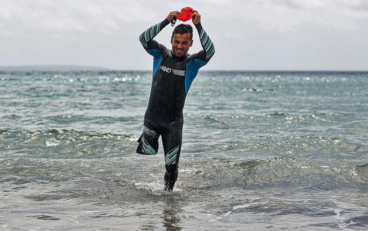 El integrante de Presuntos Triatletas sale del agua tras completar unos metros a nado en Ses Salines. | T.E.