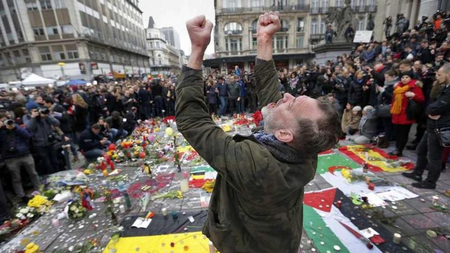 Un hombre alza sus puños y su vista al cielo en la concentración en memoria de las víctimas en Bruselas. // Reuters