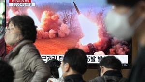 Pasajeros en una estación de Seúl pasan por delante de una televisión que emite imágenes del misil lanzado por Corea del Norte.