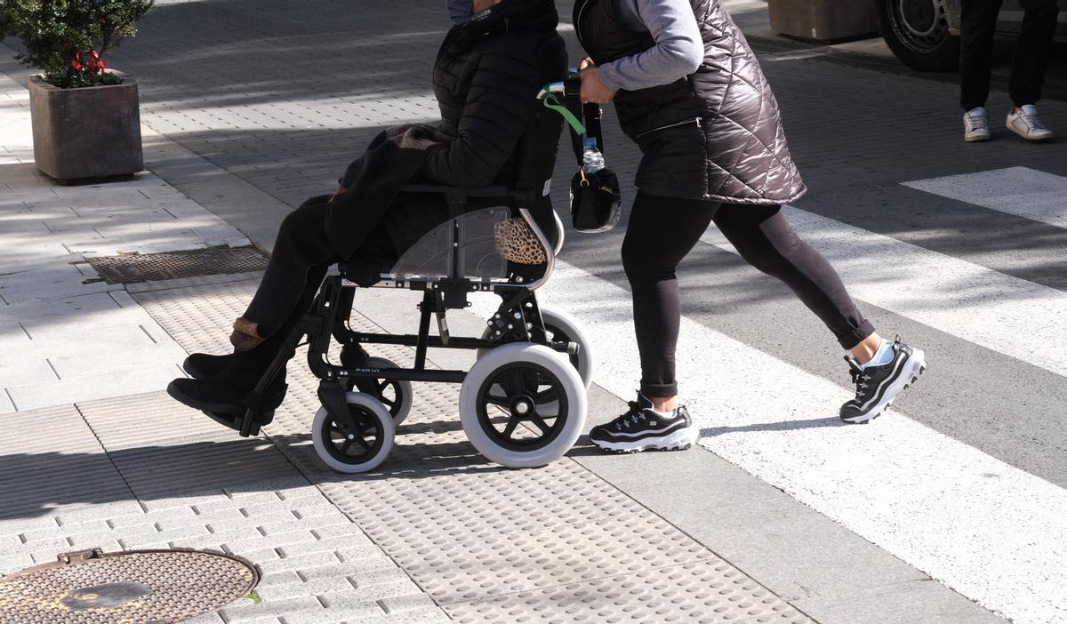 Una persona dependiente, ayudada por su cuidadora.