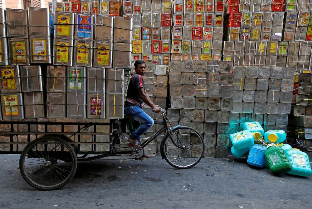 A man pedals a tricycle loaded with empty ...