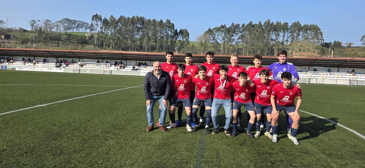 Bertin Llera  agachado, en el centro y con la medalla al cuello,  posa con bel once titular del Ribadesella CF, junto con el alcalde Paulo García